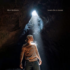 Person stands in a dark cave under a beam of light, with text Max McNown and Leave On A Light.