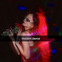 Woman in red dress and white sunglasses holds red flowers under colorful stage lights; text reads modern dance.