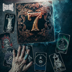 A hand with rings touches tarot cards around a central ornate card with a red "7." The background is dark and smoky, creating a mystical mood.