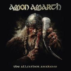 Album cover of Amon Amarth: bloodied Viking warrior in helmet holds a horn and dagger; text reads The Allfather Awakens.