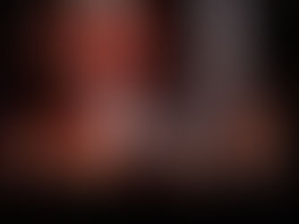 Band performing on stage with guitars, drums, and keyboard. Bright spotlights and fog accentuate musicians. Audience silhouetted in foreground.