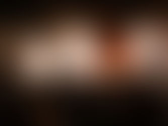 Silhouetted band performs on a lit stage with instruments; audience watches. Smoke and swirling patterns create a dramatic atmosphere.