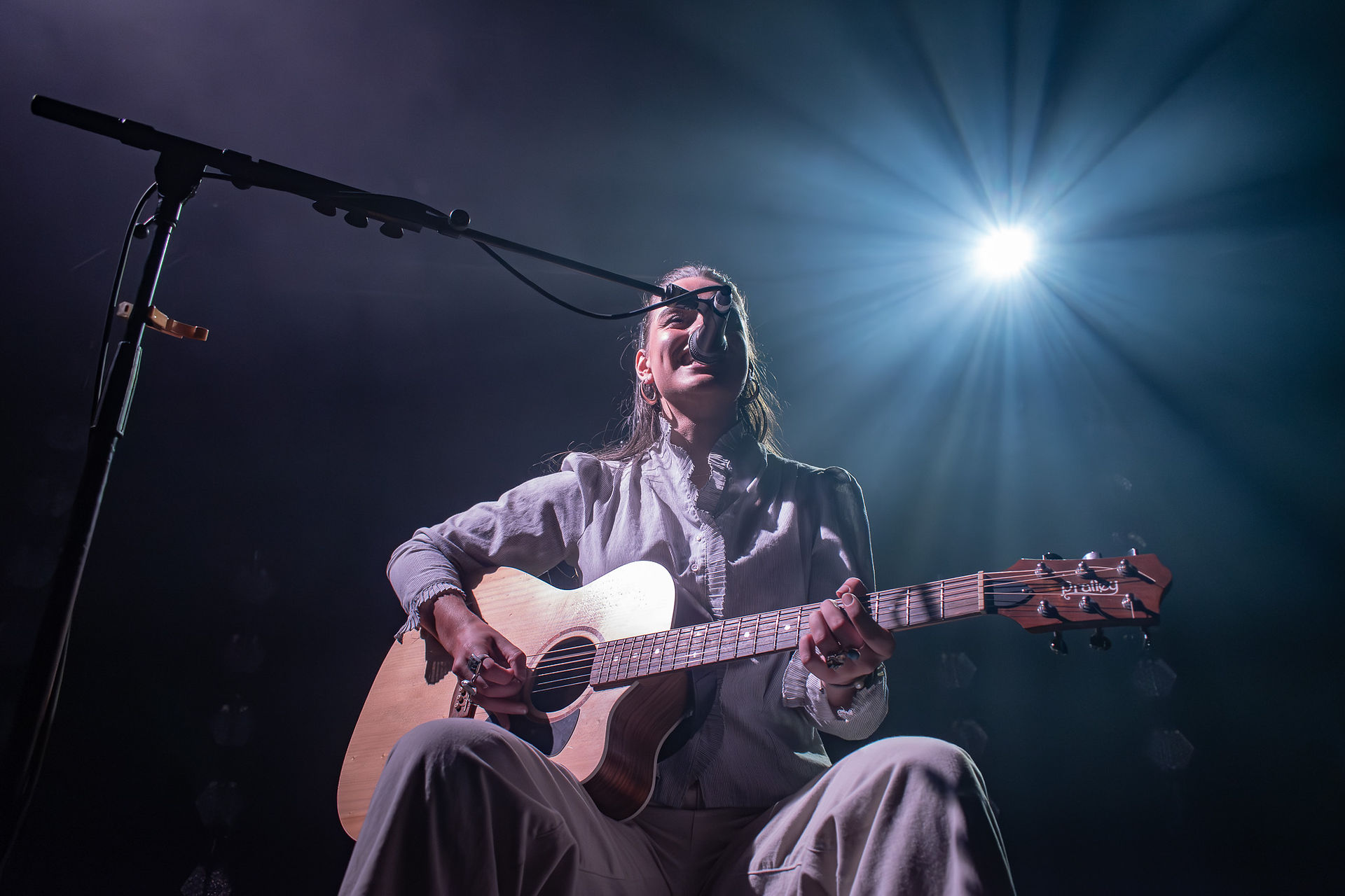 Steph Strings performing with just an acoustic guitar and microphone in Winnipeg.