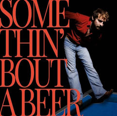 Man in red shirt and jeans leans forward on blue floor, black background. Large red text reads "SOMETHIN' 'BOUT A BEER." Energetic mood.