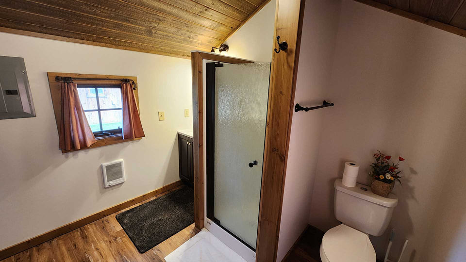 Cabin bathroom with shower and toilet at Hangman’s Guest Ranch