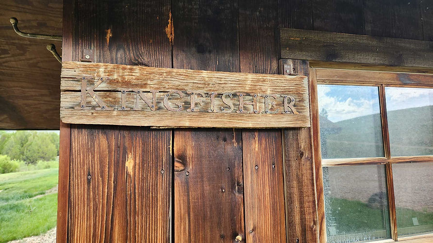 Weathered sign reads: "Kingfisher Cabin" at Hangman’s Guest Ranch