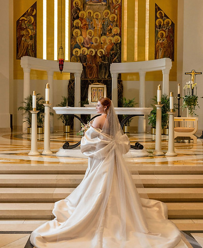 Bride in cathedral-length veil and gown standing at ornate church altar, Chicago luxury wedding planned by Frank Event Design. Photo by LaCour Images