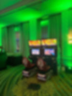 Mario Kart arcade racing game setup with dual seats and screens under green uplighting at a corporate event by Bright Light Events