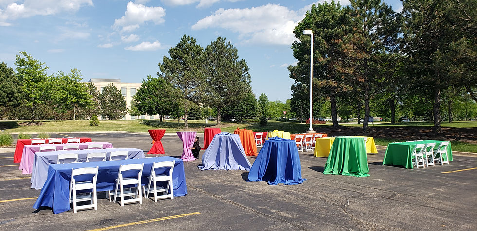 Blue, red, green and yellow table cloths at an outdoor event