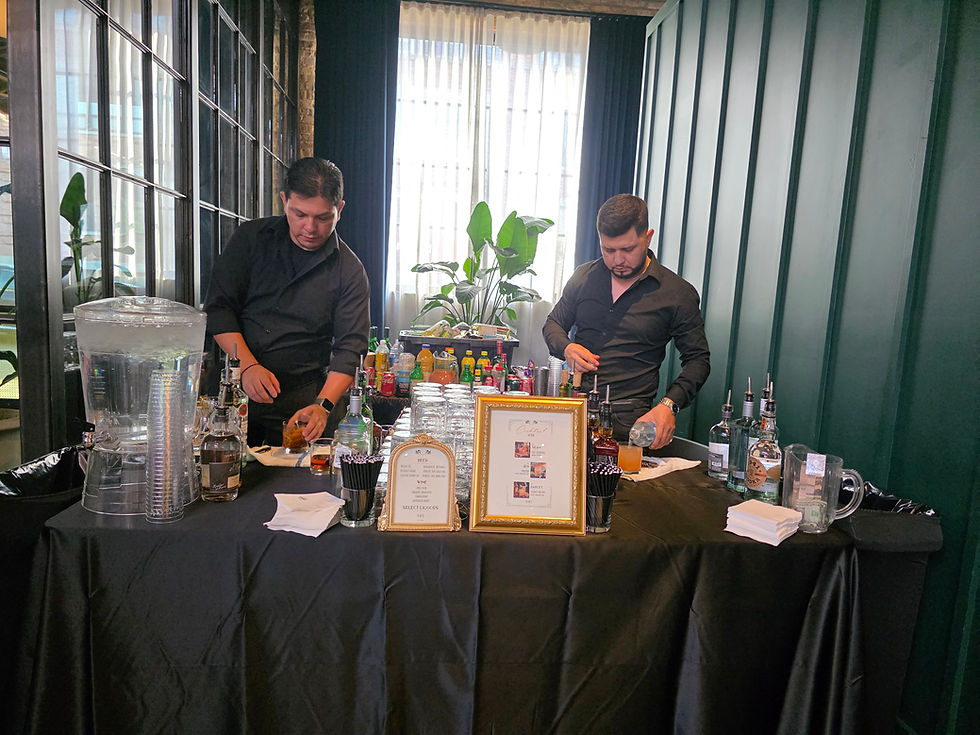 Two bartenders setting up a full wedding bar with spirits and glassware at an industrial Chicago venue