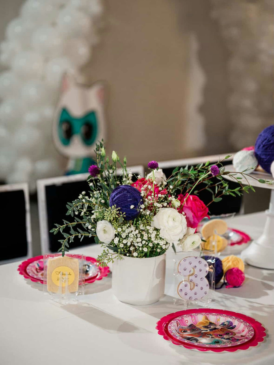 Birthday celebration table at Fulton West decorated with yarn ball centerpieces, fresh flowers, and playful owl-themed décor.