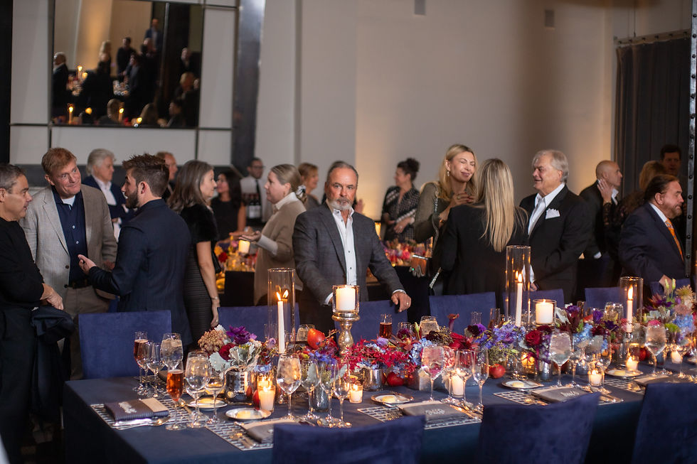 Guests mingling beside candlelit tables during a Chicago birthday dinner celebration.