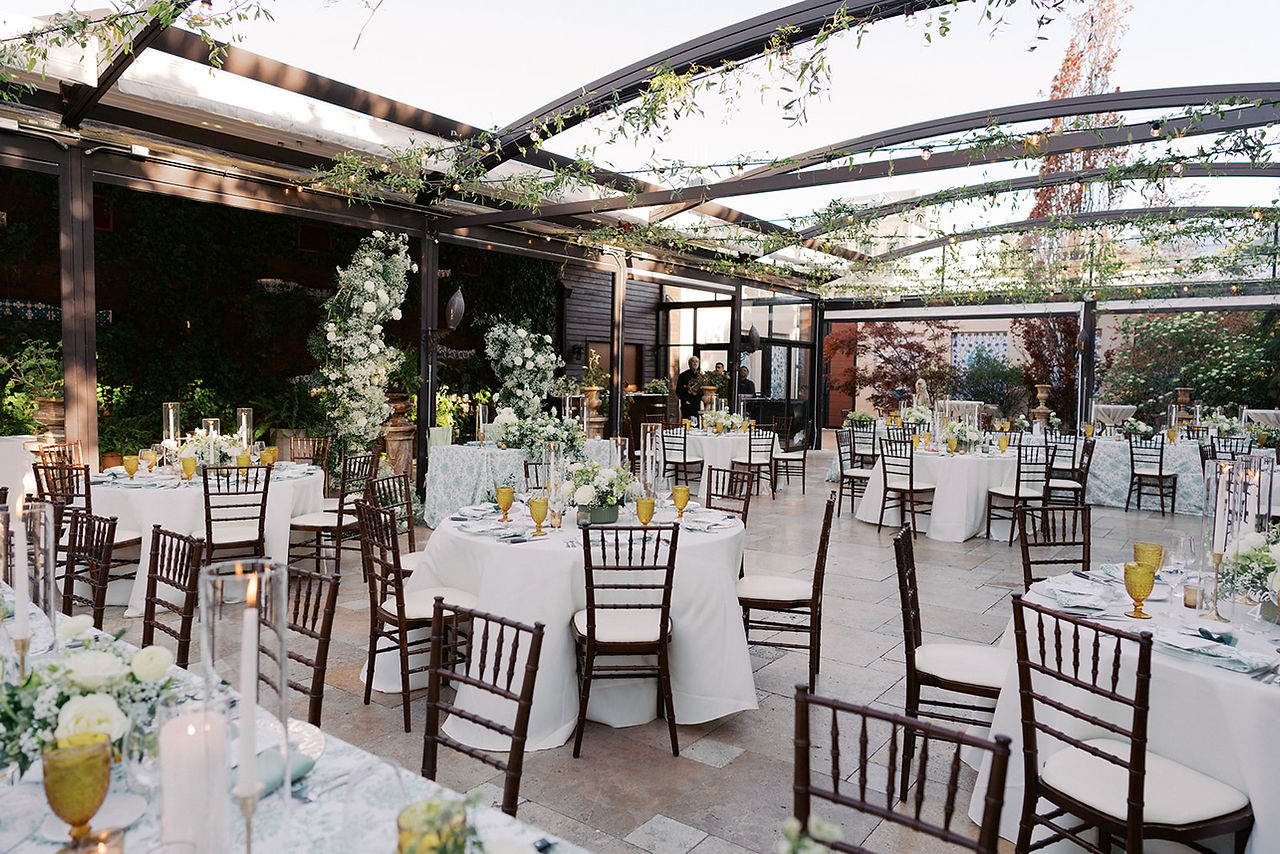  Outdoor reception setup at Galleria Marchetti with garden greenery, floral linens and candlelit tables for Lisa and Dan’s wedding.