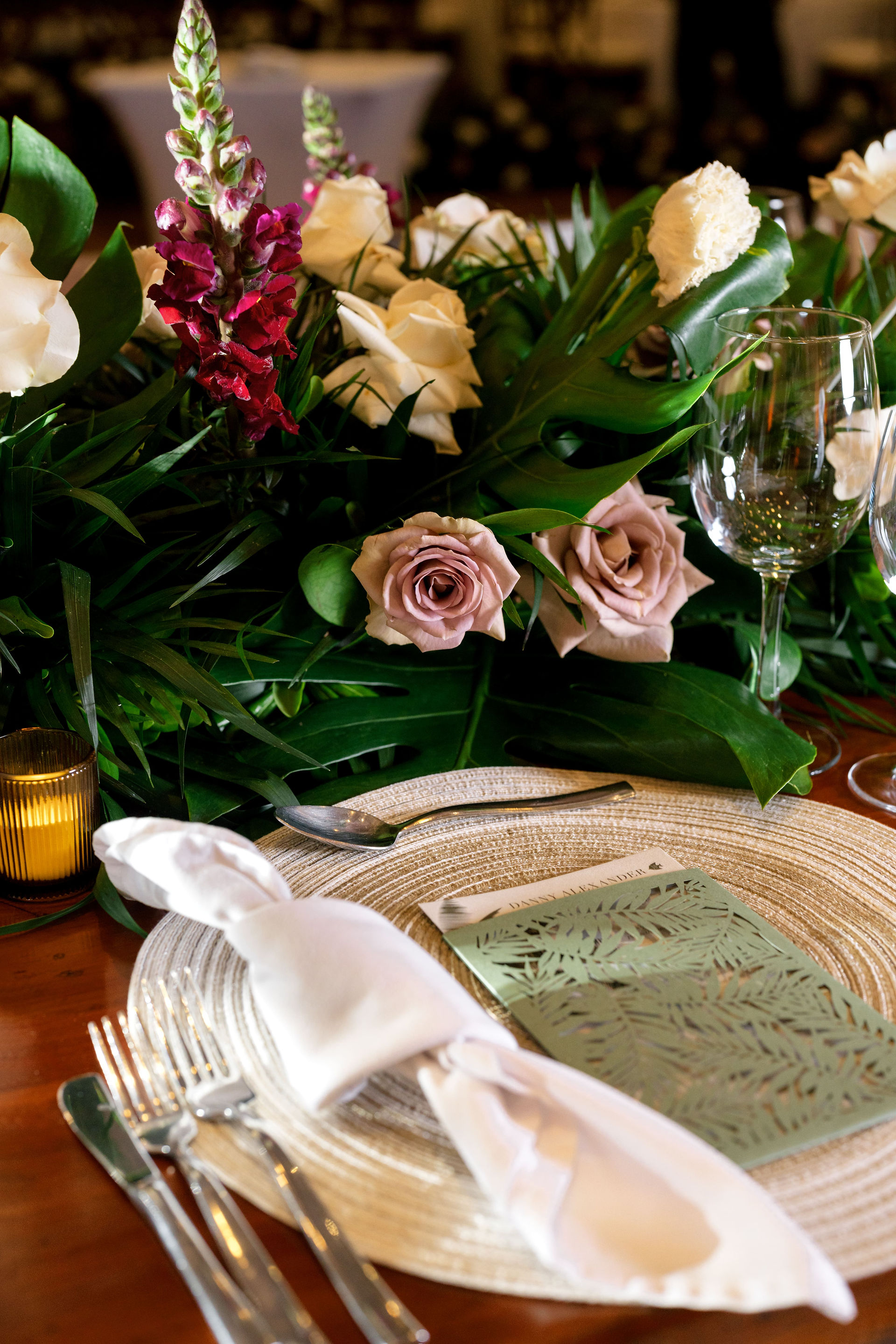 Pink and purple flowers and tropical arrangements on wedding reception table