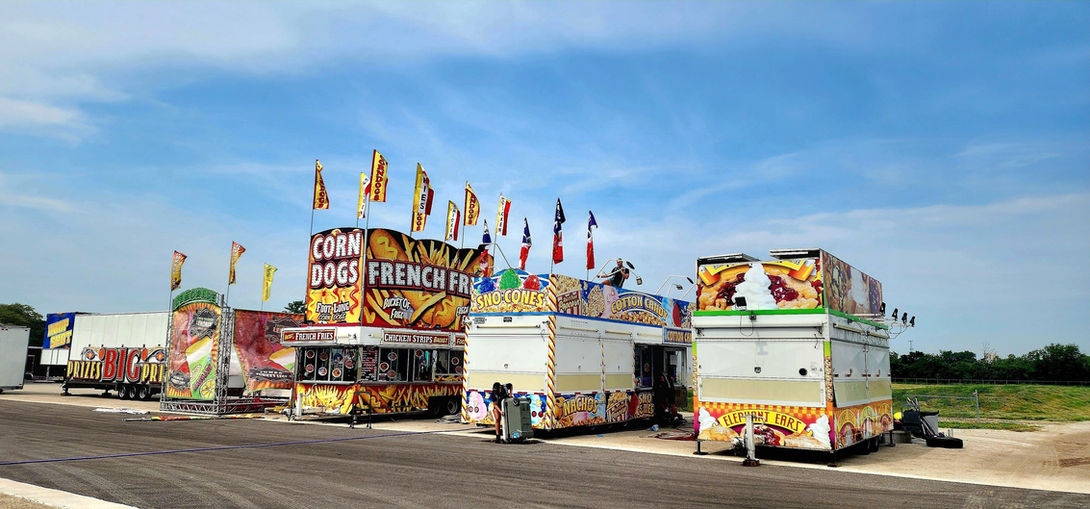 Carnival food stands with corn dogs and sno cones at Old Canal Days.