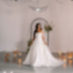 A bride posing in a full wedding gown beside a floral ceremony arch at a Chicago wedding venue.