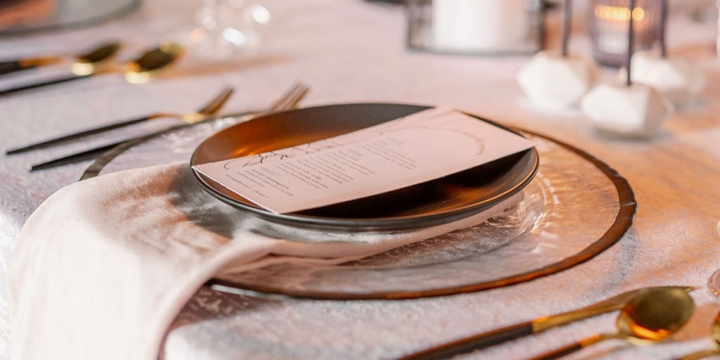 Close-up of modern black place setting and printed menu used inside our Chicago event venue.