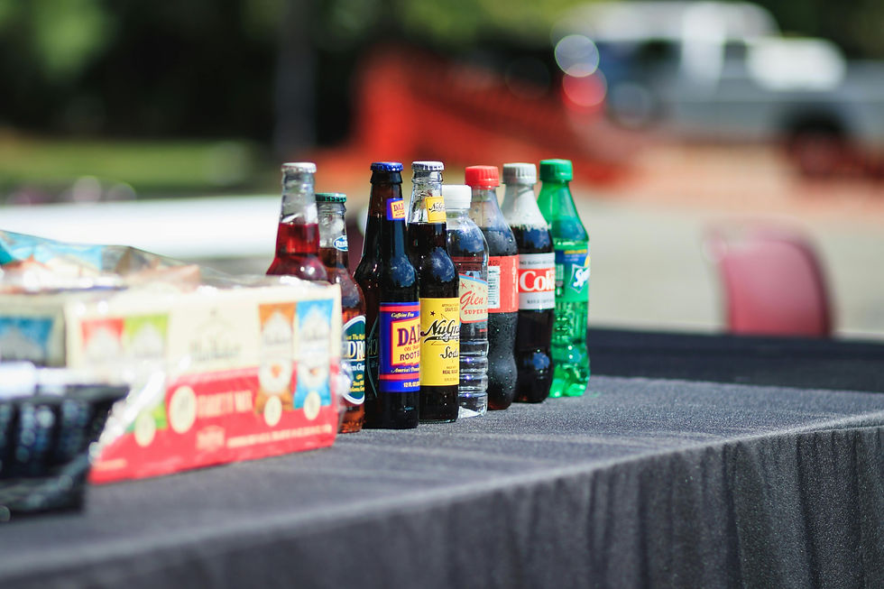 Bottles of soda on a black table cloth at an event