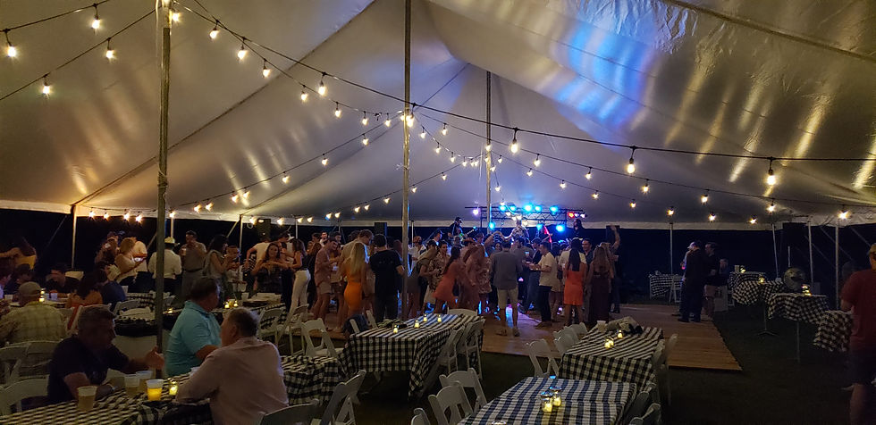 Guests having fun on the dance floor at a tented event