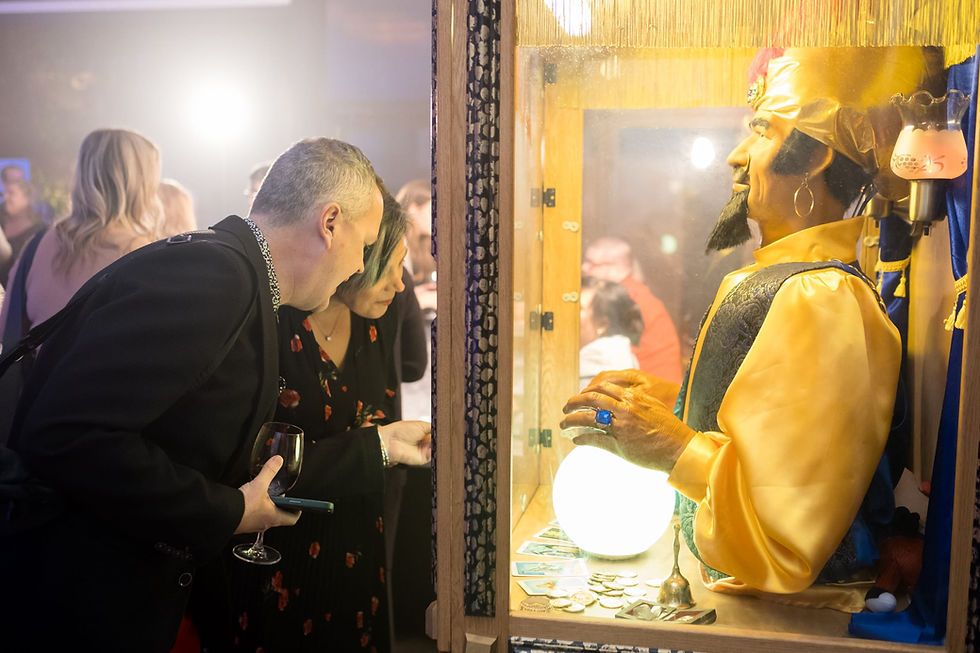 Two guests interacting with Zoltar fortune teller at an event