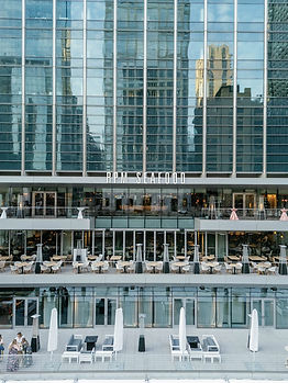 Exterior view of the RPM Seafood building along the Chicago River, showing tiered outdoor terraces with dining furniture overlooking the water, home to RPM Events on the Water.
