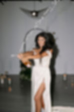 A joyful bride in a white gown popping champagne inside a contemporary Chicago wedding venue.