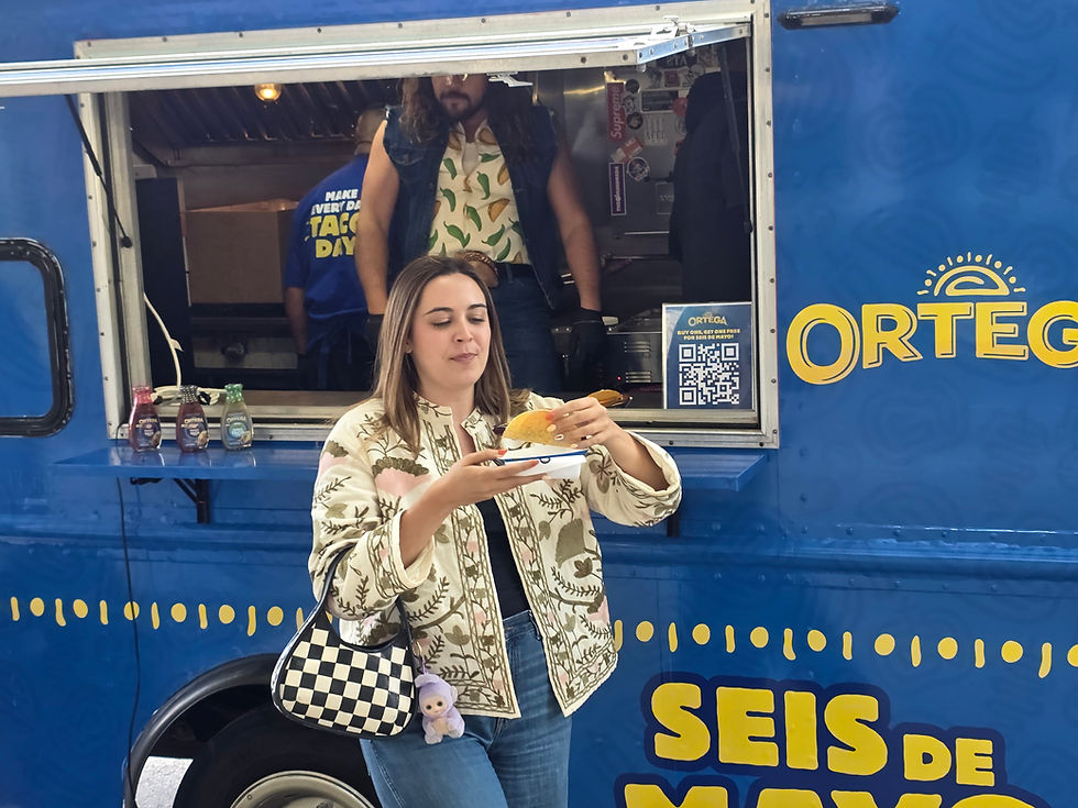 Event guest enjoying a taco in front of the Ortega Seis de Mayo branded food truck at a Chicago catering event