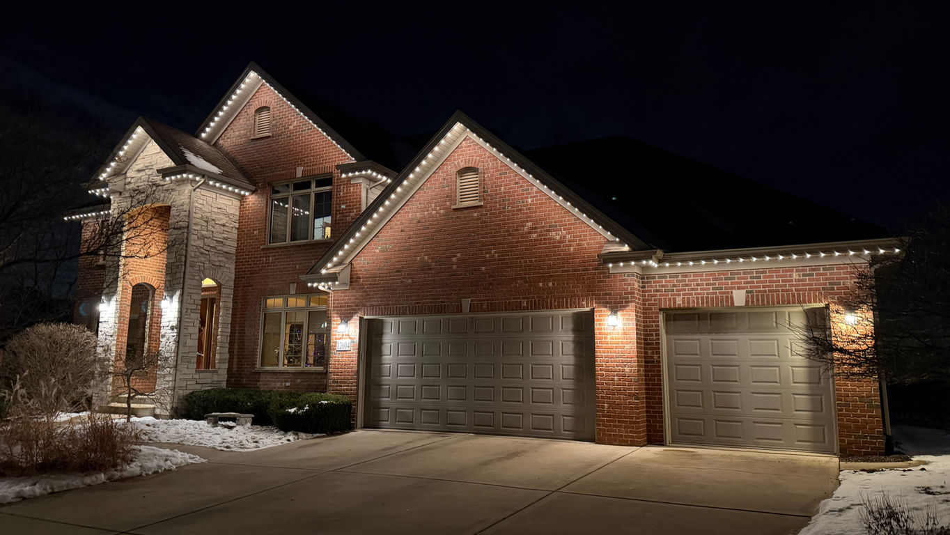 Warm white architectural permanent holiday lighting on a house