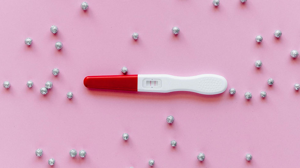 Positive pregnancy test with double lines on a pink background with silver decorations.