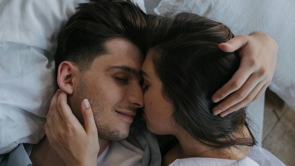 Close-up of a loving couple embracing and resting peacefully in bed.
