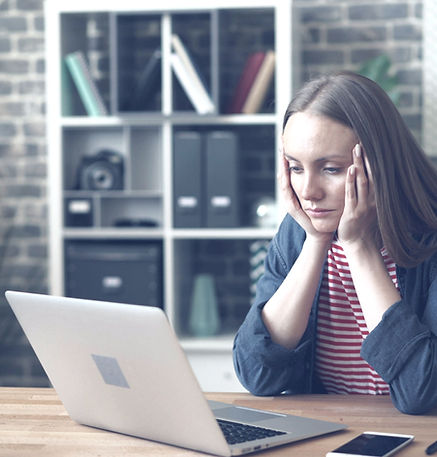 Tired young woman using laptop in office