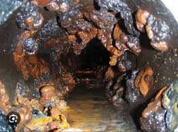 Looking inside a cities main water line, with rusty, brown water sitting in the bottom of the pipe