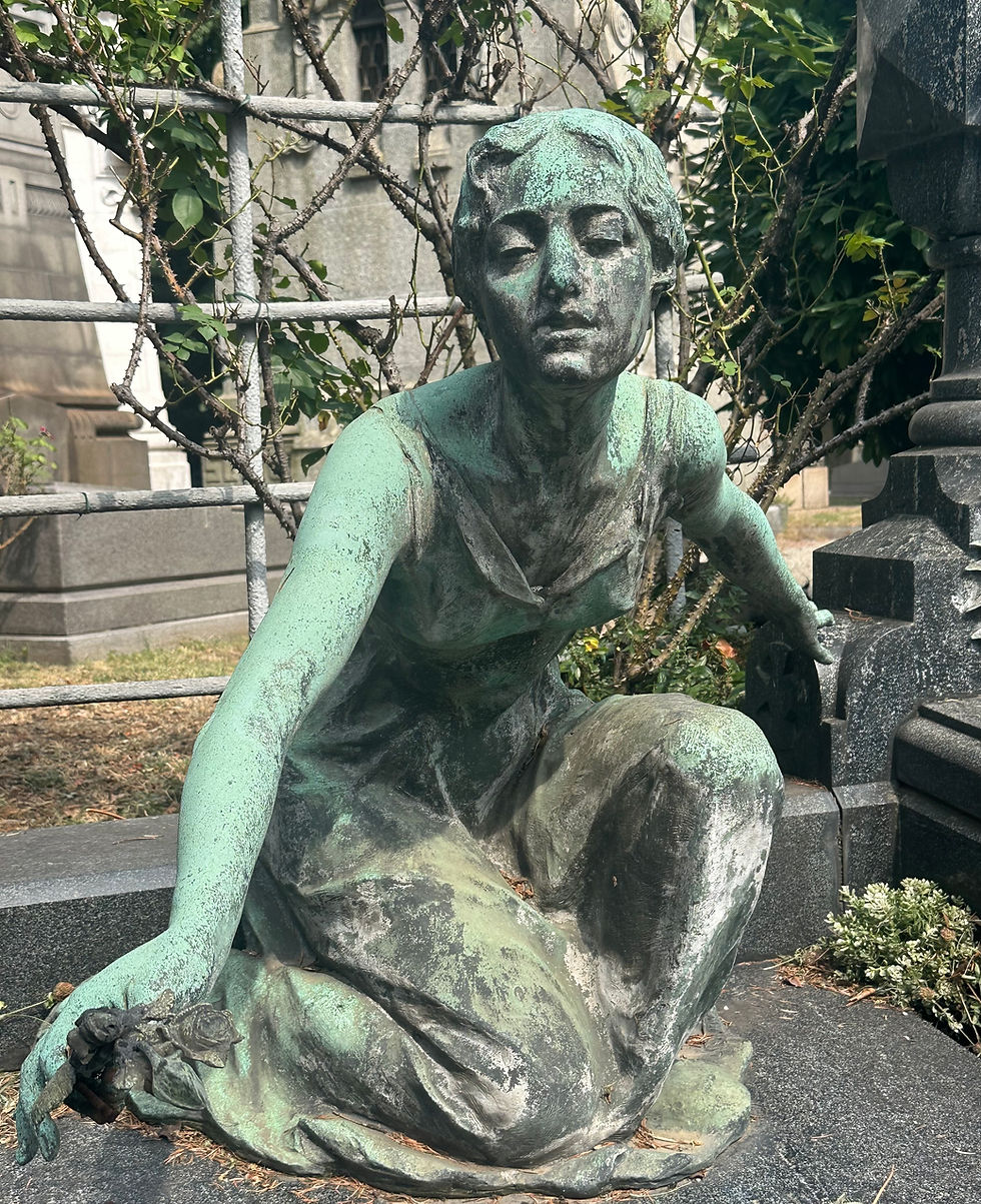 Patinated statue of a woman kneeling with an arm outreached
