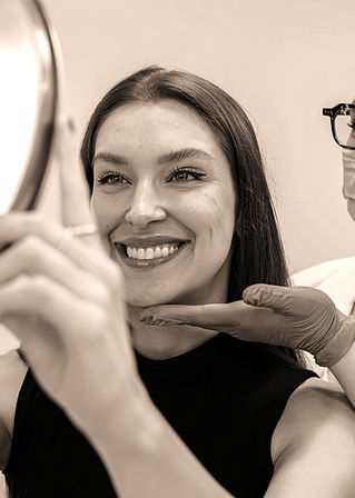 Smiling woman with mirror and doctor's hand, VIVE Medical aEsthetics.