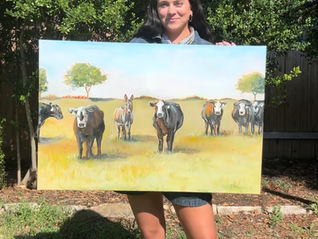 Avery Miller of A. Curtis Creations holding up an original art piece in austin texas - live wedding painter, live event painter