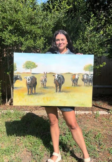 Avery Miller of A. Curtis Creations holding up an original art piece in austin texas - live wedding painter, live event painter