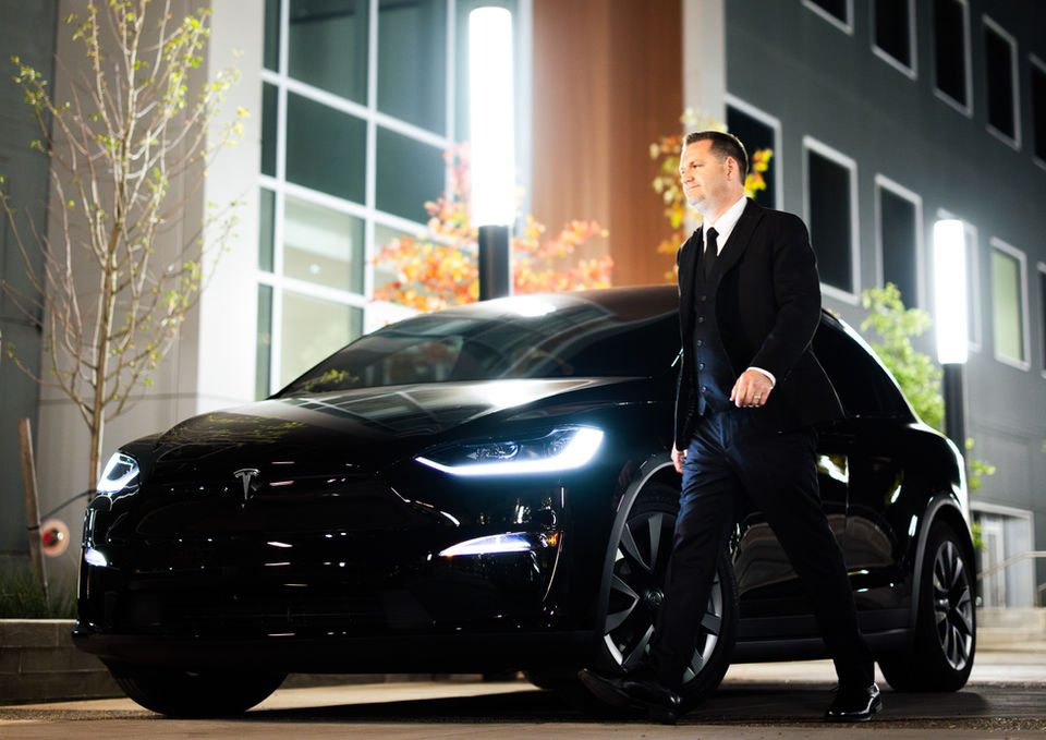 Night out in Portland, OR: handsome chauffeur and sophisticated black car (town car) await passenger who values quiet luxury.