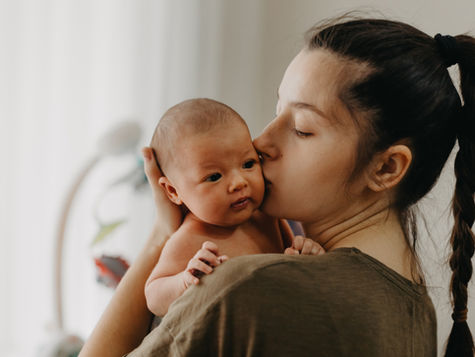 mother kissing baby cheek