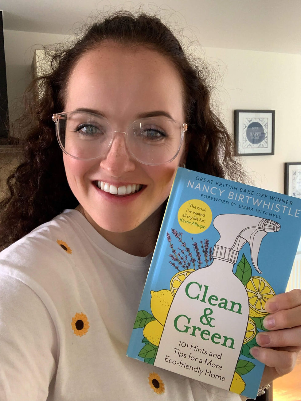 eco sal owner Sally smiling and holding Nancy Birthwhistles book called Clean and Green