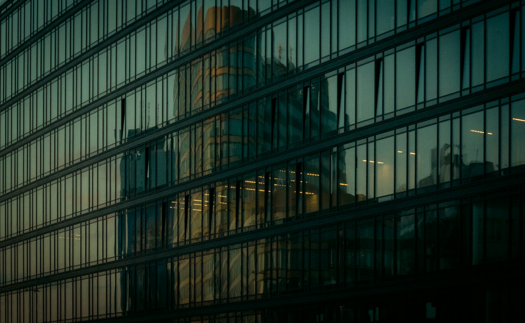 Reflective glass facade of a commercial office building, used as an illustrative visual for operational resilience.