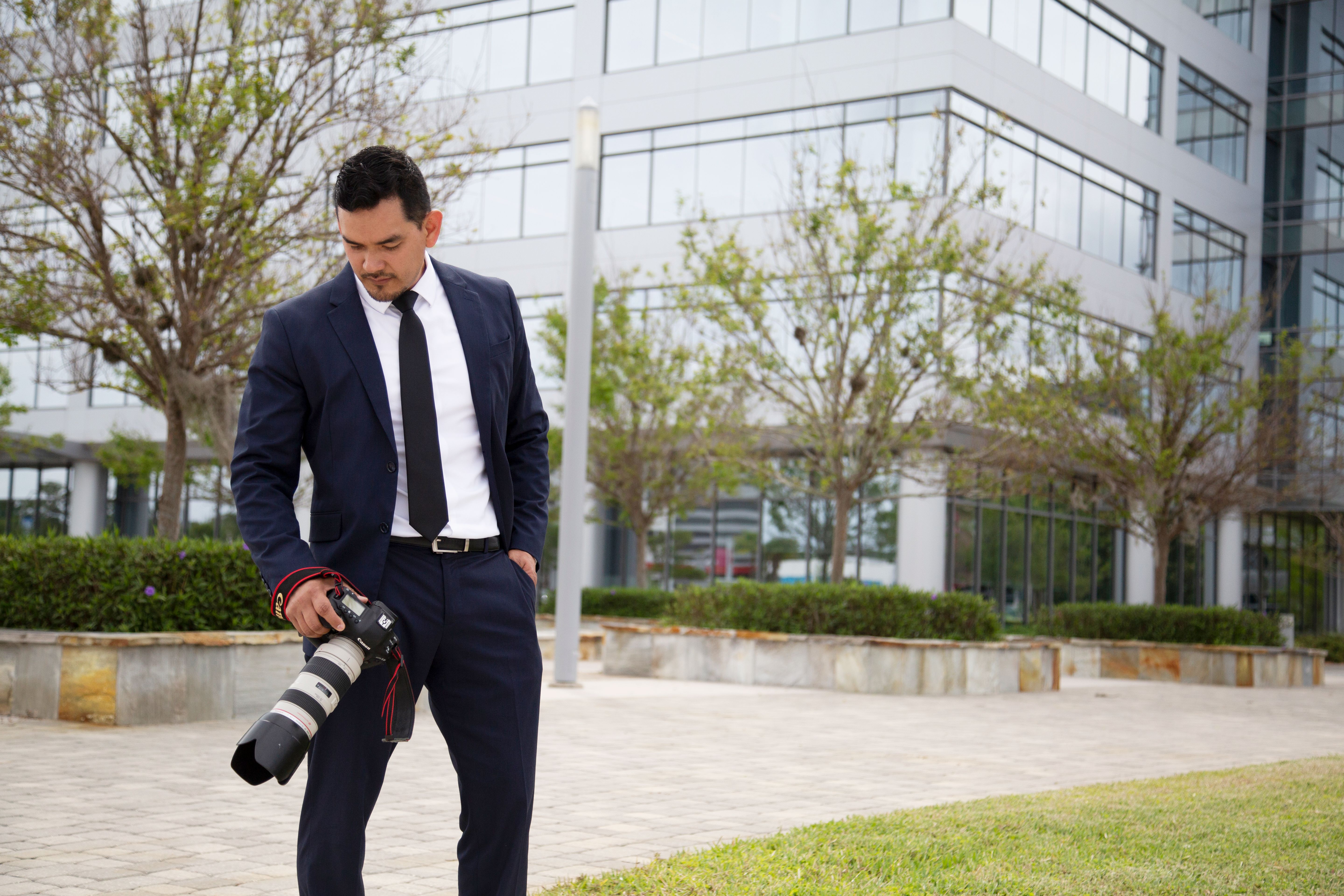 Professional photographer preparing camera equipment for corporate event coverage
