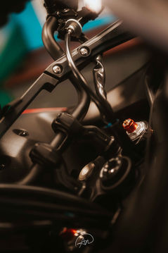 Precision industrial matt black motorcycle components and orange dial detail for engineering and manufacturing firms.