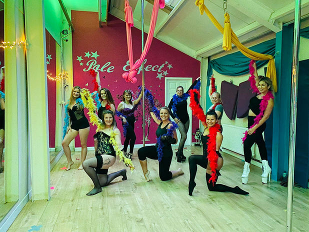 Group of women posing with boas at the Pole Effect Worcester studio.