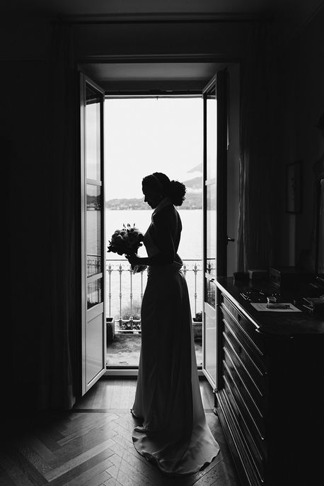 black and white portrait in dramatic light of bride holding bouquet