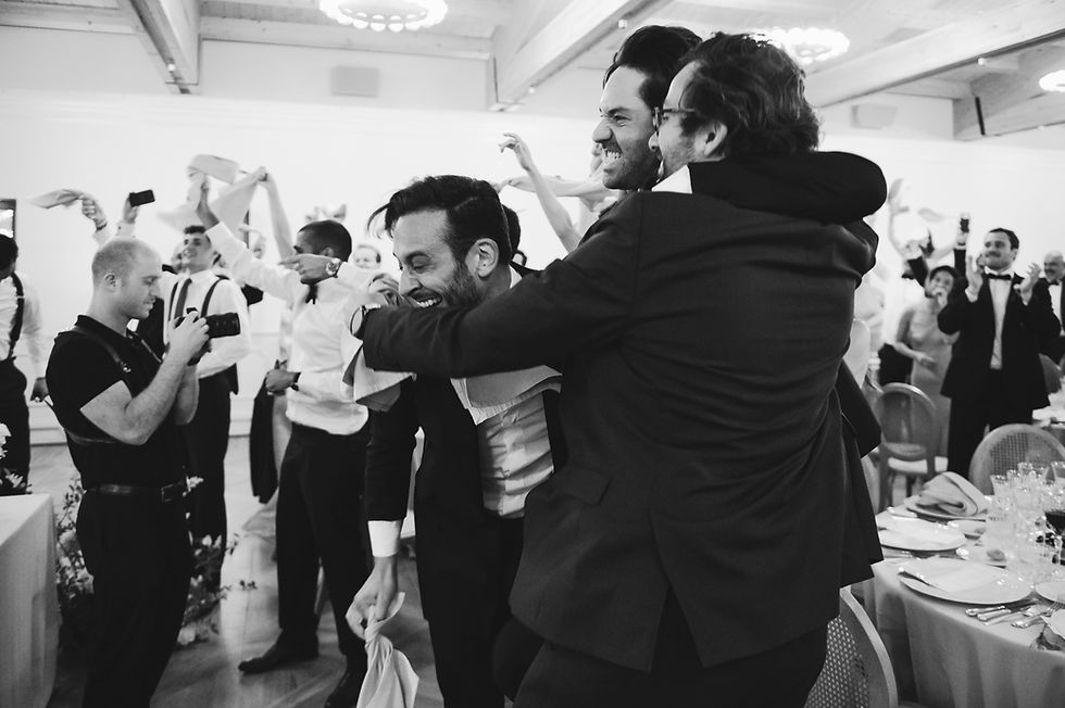 wedding reception with guests hugging and laughing cheering and waving napkins