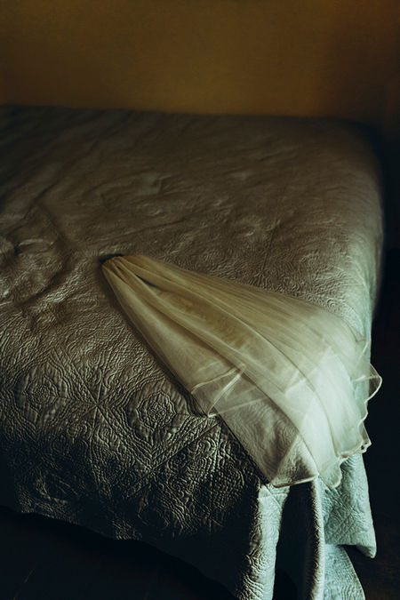 detail of bride veil on bed in dramatic light
