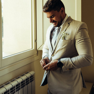 groom closing upo suit for wedding in Tuscany