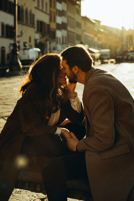 couple kissing in a beautiful sunrise in a scenic street of Florence