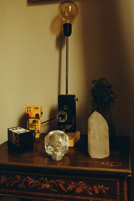 detail of a side table with an old camera, crystals and camera rolls 