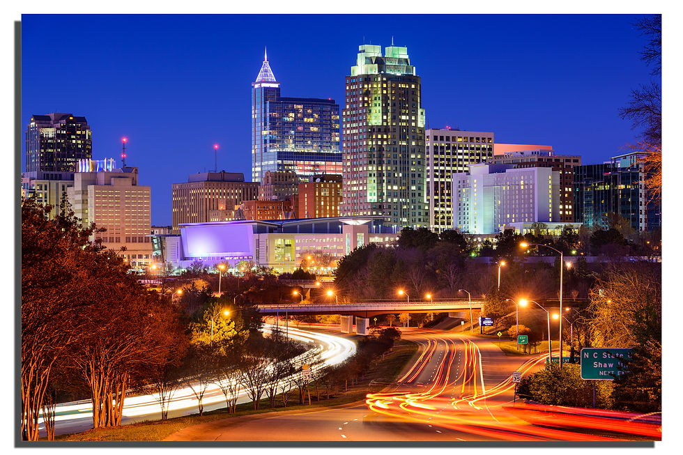 Eye-level view of downtown Raleigh skyline with cranes and construction sites